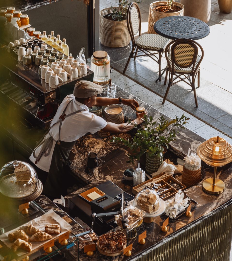 A Whippet barista finishing a coffee at the pass